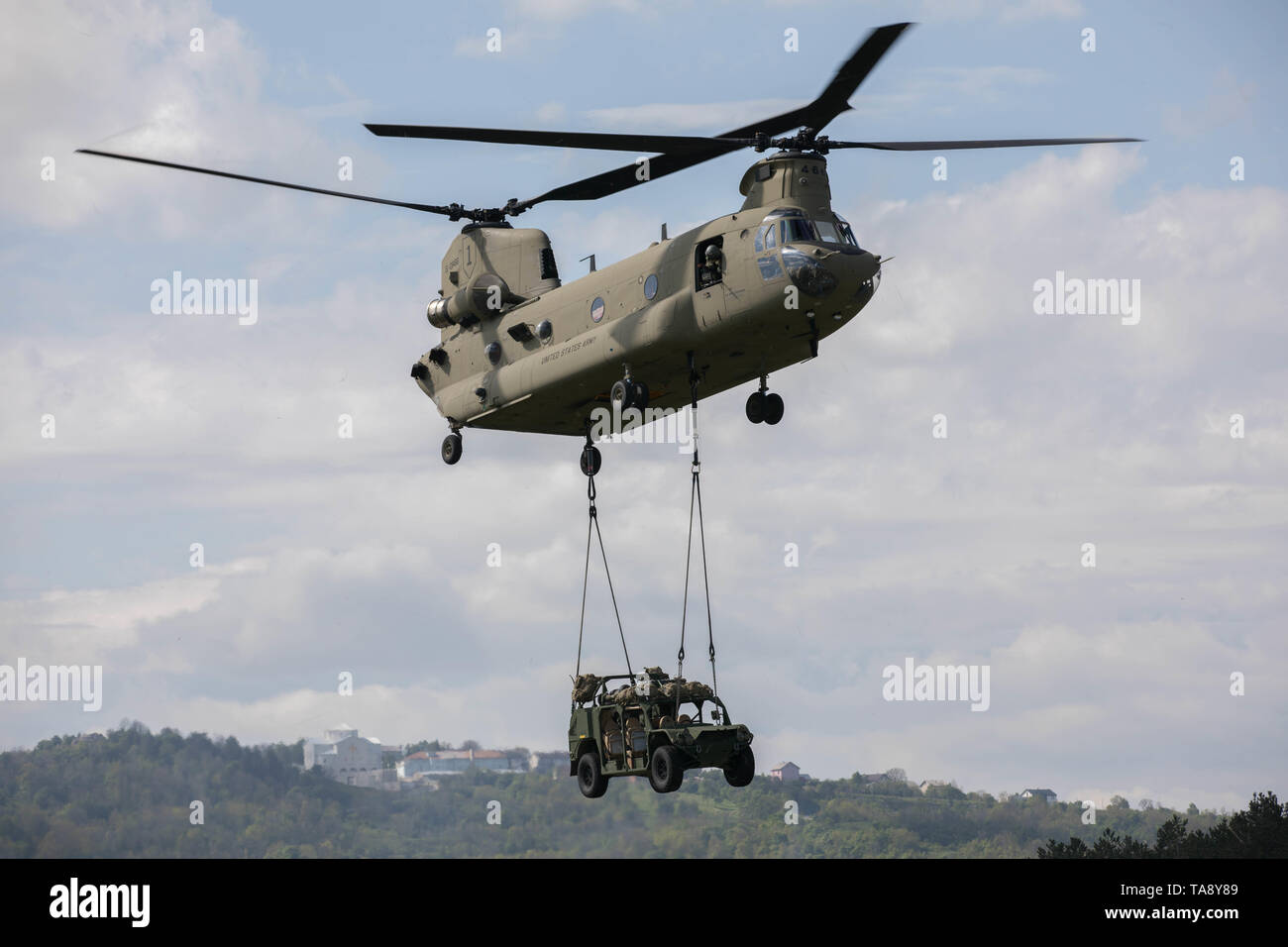 Un U.S. Esercito CH-47 elicottero Chinook, assegnato al Bravo Company, 2° Battaglione, 1a combattere la Brigata Aerea, 1a divisione di fanteria, conduce un assalto dell'aria missione con un esercito di mobilità di massa veicolo (AGMV) sling caricato con i paracadutisti assegnato alla società di attacco, 1° Battaglione, 503rd Reggimento di Fanteria, 173rd Brigata Aerea, caricati a bordo durante l'esercizio una risposta immediata a Vojarna Josip Jovic Airbase, Udbina, Croazia, 17 maggio 2019. Esercizio risposta immediata è un esercizio di multinazionale co-guidato dal croato di Forze Armate, Sloveno Forze Armate, E DEGLI STATI UNITI Esercito europeo. La logistica-focalizzata Foto Stock
