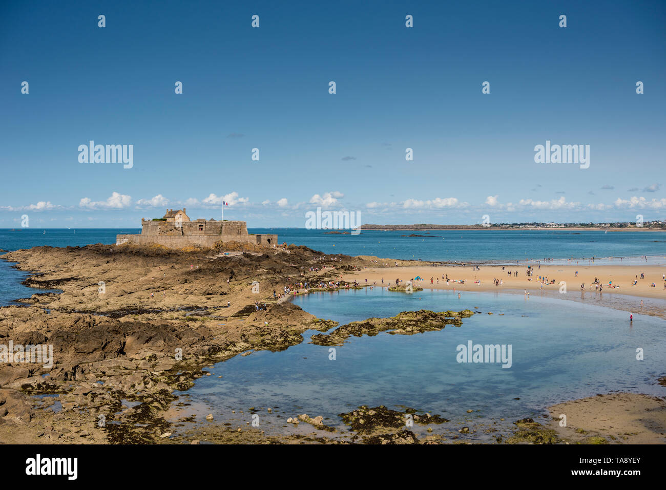 La gente sulla spiaggia sabbiosa e la vista del mare con il Fort National in background, Bretagna Francia Foto Stock
