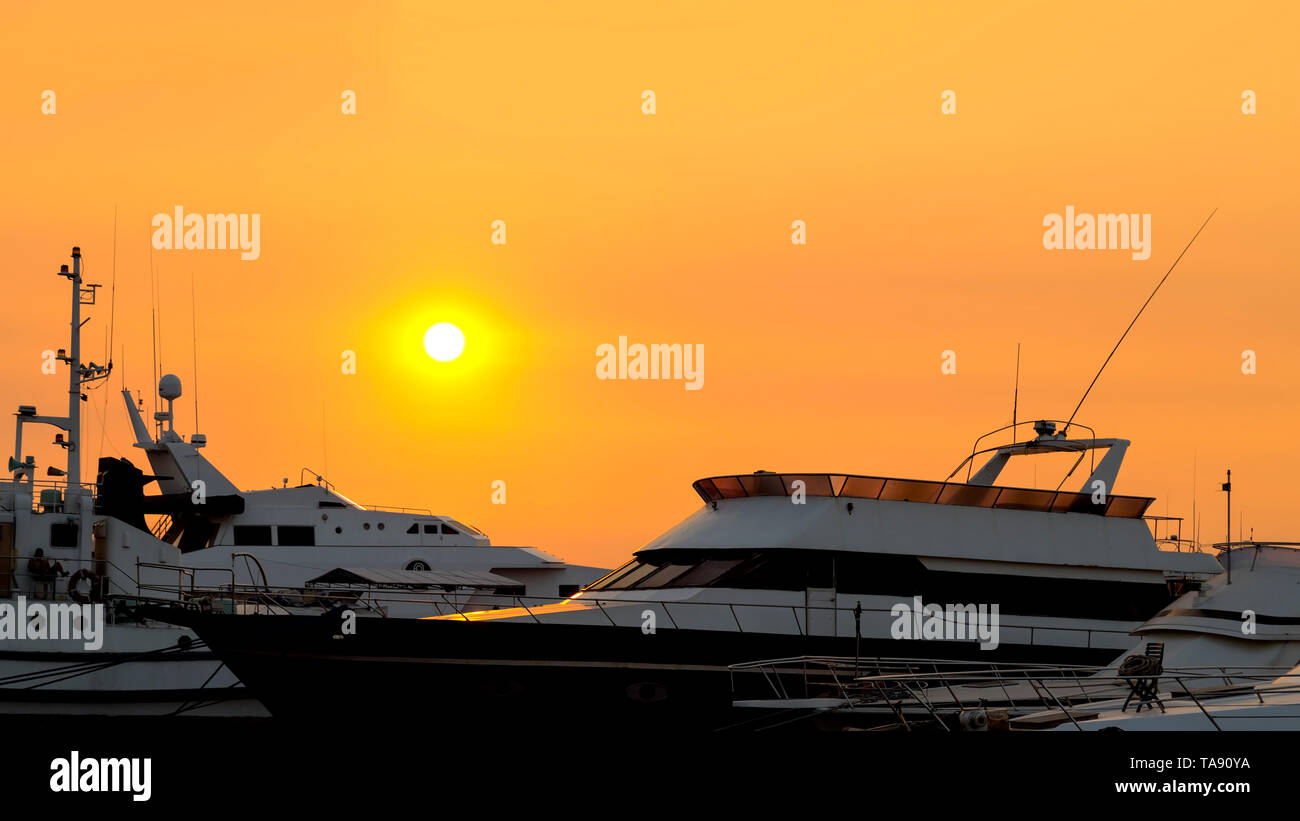 Yacht sul tramonto arancione Foto Stock