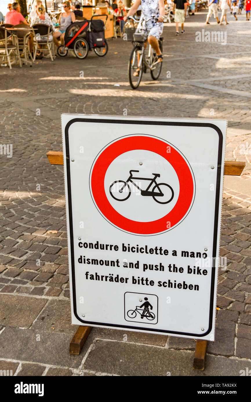 GARDA LAGO DI GARDA ITALIA - Settembre 2018: Segno sul lungomare di Garda sul Lago di Garda chiedendo ai ciclisti di smontare e spingere le bici per la sicurezza ri Foto Stock