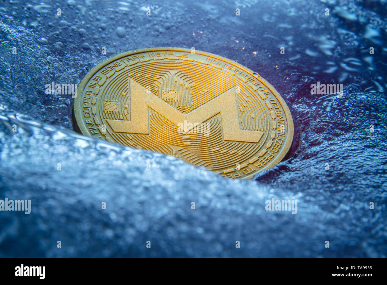 Golden Monero coin, online valuta digitale congelati nel blu ghiaccio. Concetto di catena di blocco, crypto crash del mercato. Congelati crypto denaro, ammortamento Foto Stock