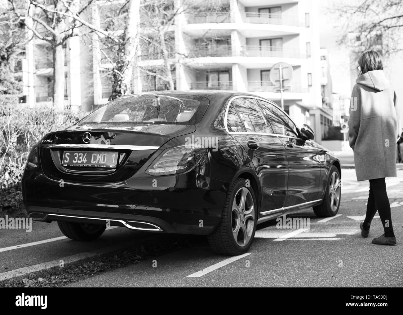 Strasburgo, Francia - Feb 23, 2017: Donna che cammina verso il nuovo status di Mercedes-Benz E220d diesel auto parcheggiata su una strada tranquilla nella città francese Foto Stock