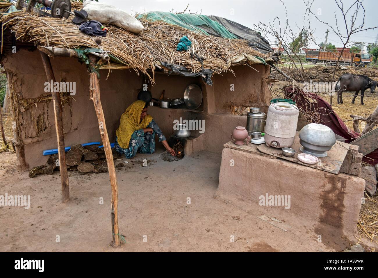 Un indiano nomad donna vede la cottura su un combustibile efficiente stufa in Patiala distretto del Punjab (India). Foto Stock