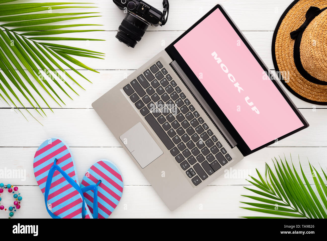 Mock up display del computer portatile su bianco tavolo in legno per Vacanze Estate vacanza il concetto di sfondo. Appartamento laici vista superiore del Notebook portatile, fotocamera accessor Foto Stock