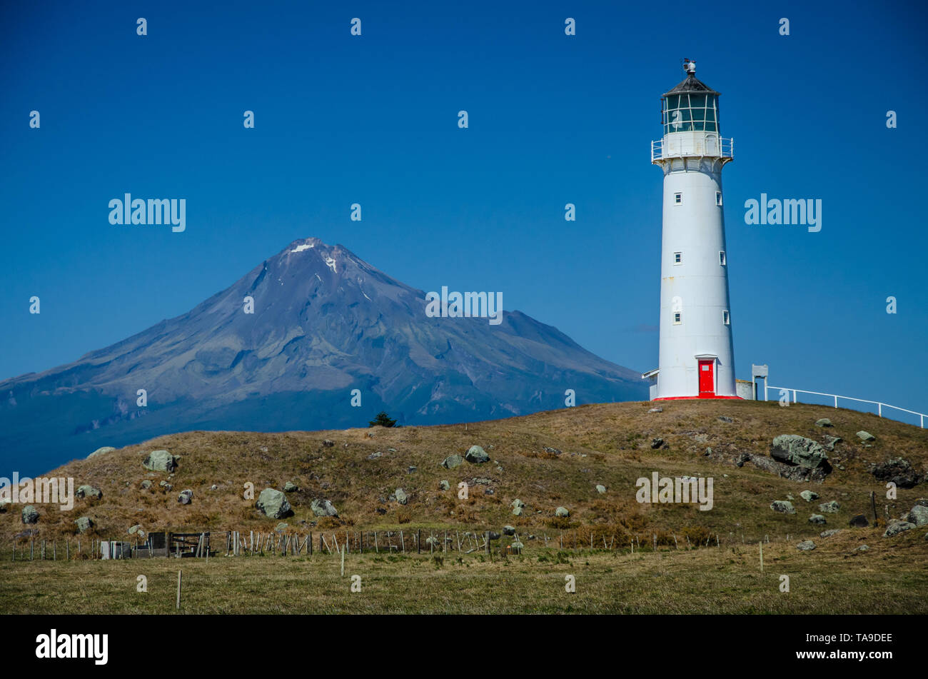 Capo Faro Egmont con il Monte taranaki in background e cielo blu sopra. Egmont National Park, Nuova Zelanda Isola del nord. Foto Stock