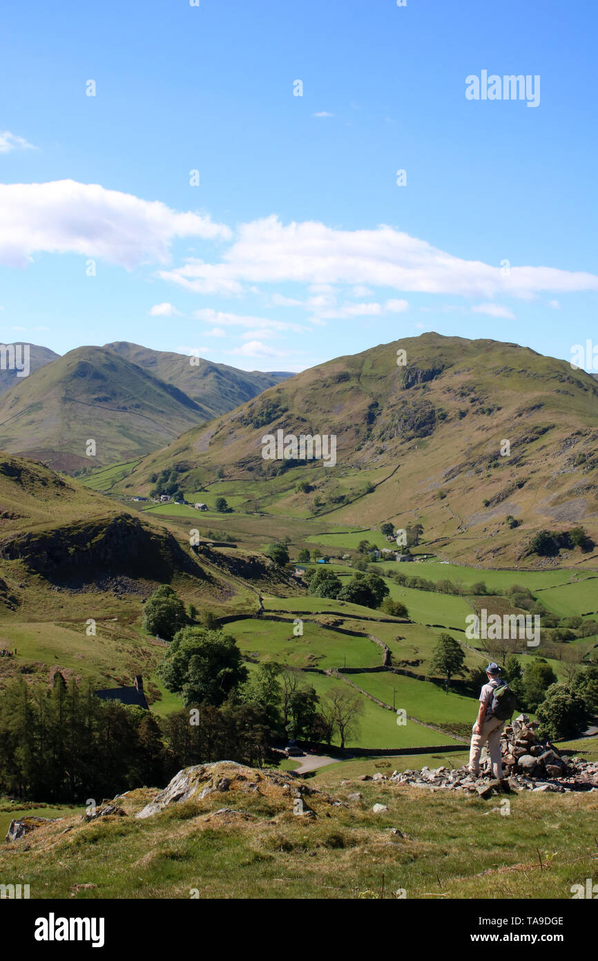 Vista sud dalle pendici meridionali di Hallin cadde nel Lake District, Cumbria con maschio walker guardando a vista sul Martindale al NAB e Beda cadde. Foto Stock