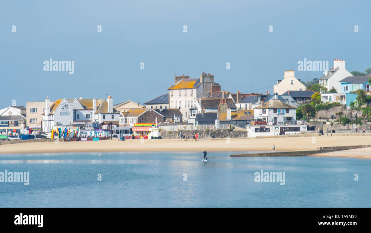 Lyme Regis, Dorset, Regno Unito. Il 23 maggio 2019. Regno Unito: Meteo una gloriosa mattina presso la pittoresca spiaggia della località balneare di Lyme Regis. Il popolare resort è calmo e tranquillo oggi in vista delle prossime vacanze di maggio. Un lone paddle boarder sfrutta le condizioni pacifiche. Folle di visitatori sono attesi al gregge per la famosa spiaggia di La prossima settimana a crogiolarvi nel mite clima che è stato meteo di tutta la costa sud dell'Inghilterra. Credito: Celia McMahon/Alamy Live News. Foto Stock