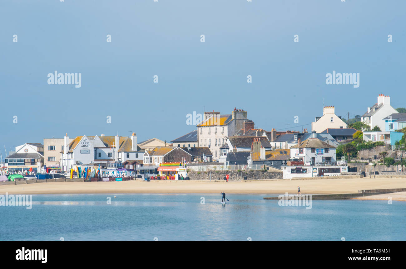 Lyme Regis, Dorset, Regno Unito. Il 23 maggio 2019. Regno Unito: Meteo una gloriosa mattina presso la pittoresca spiaggia della località balneare di Lyme Regis. Il popolare resort è calmo e tranquillo oggi in vista delle prossime vacanze di maggio. Un lone paddle boarder sfrutta le condizioni pacifiche. Folle di visitatori sono attesi al gregge per la famosa spiaggia di La prossima settimana a crogiolarvi nel mite clima che è stato meteo di tutta la costa sud dell'Inghilterra. Credito: Celia McMahon/Alamy Live News. Foto Stock