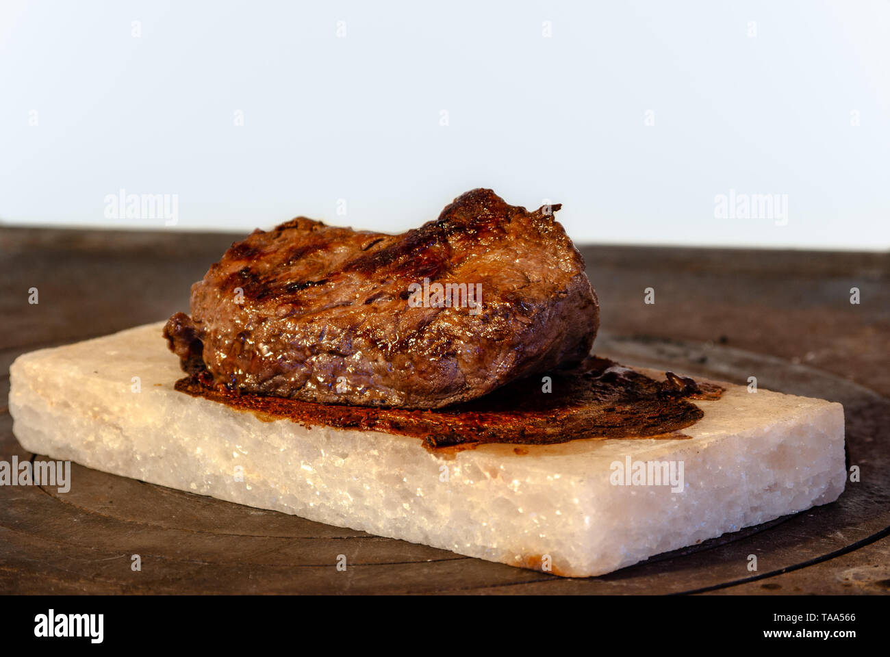 Irlandese bistecca di manzo alla griglia su Sale Himalayano sul monoblocco a legna per la stufa Foto Stock