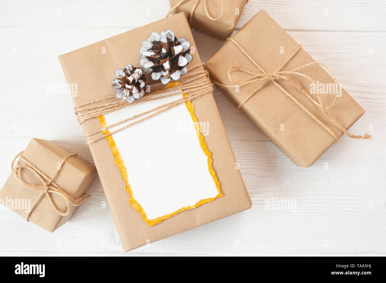 Sfondo di Natale per biglietto d'auguri foglio di carta con posto per il testo. Confezione regalo su sfondo di legno. Mockup di foto con vista dall'alto e disposizione piatta Foto Stock