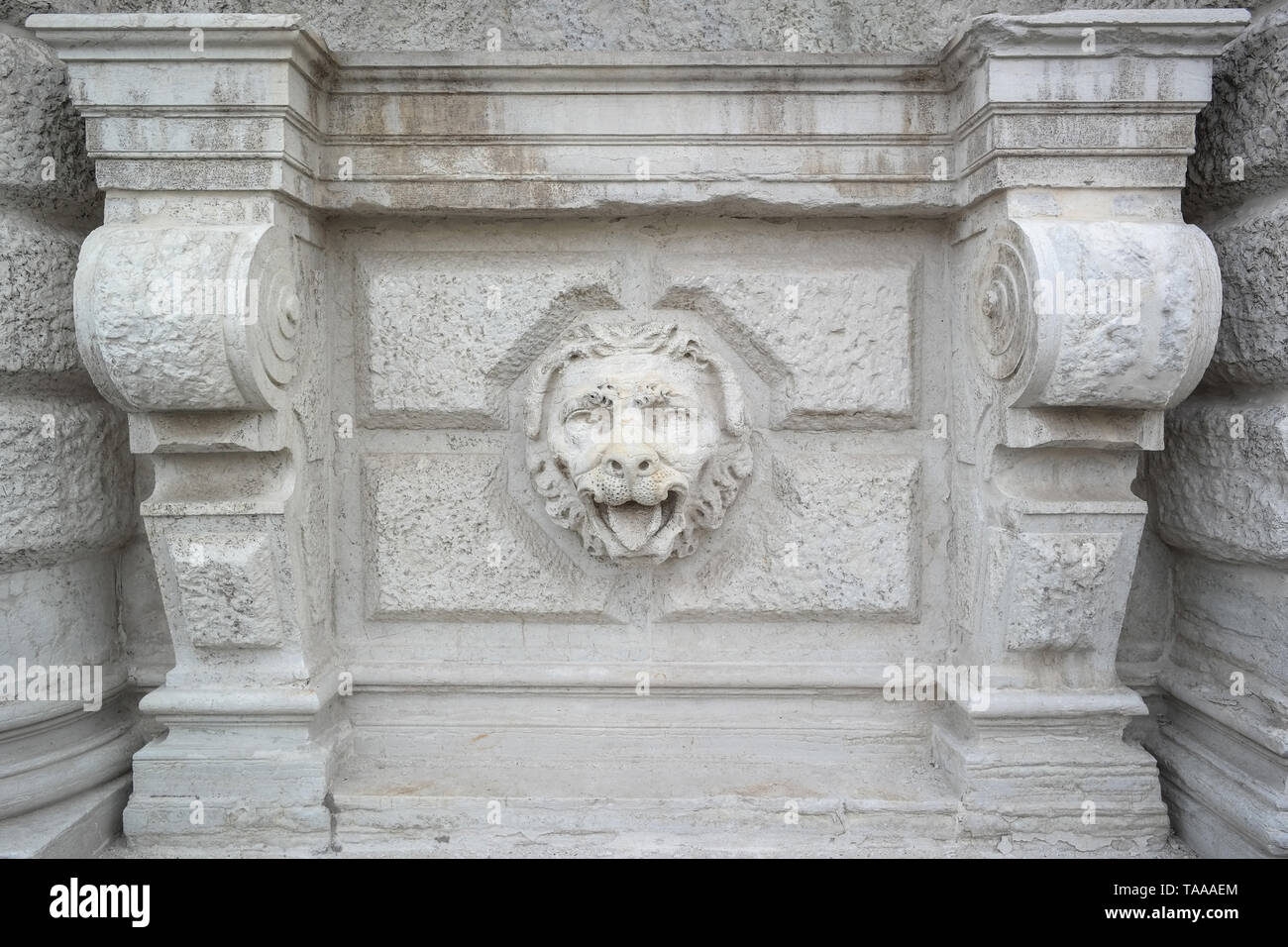 Rilievo di testa di leone scolpita in pietra su facciata consumata, dettaglio architettonico, Venezia, Italia, lavorazione classica della pietra Foto Stock