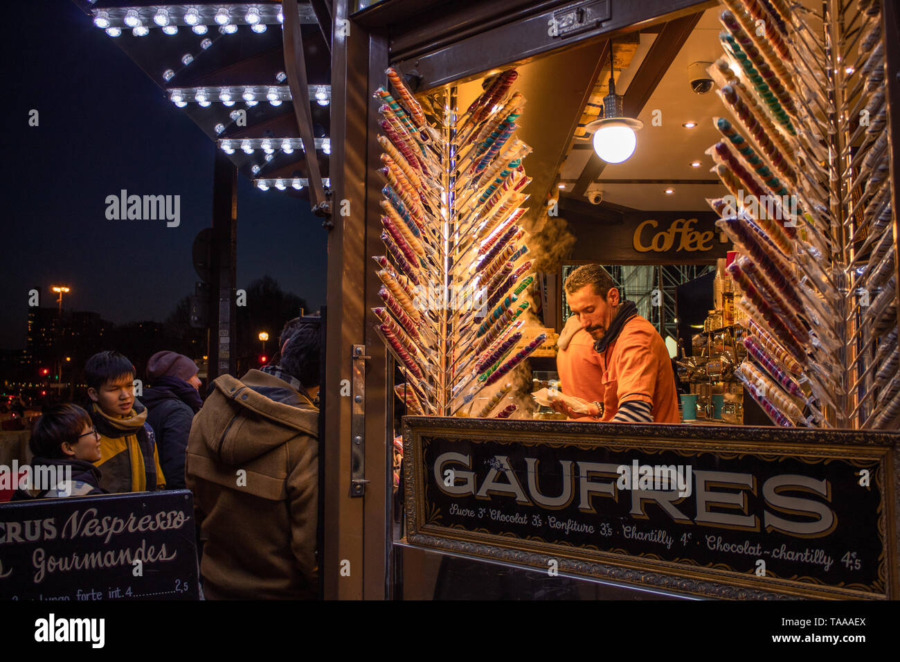 Crepes e altri dolci essendo venduto su una strada parigina di notte. Foto Stock