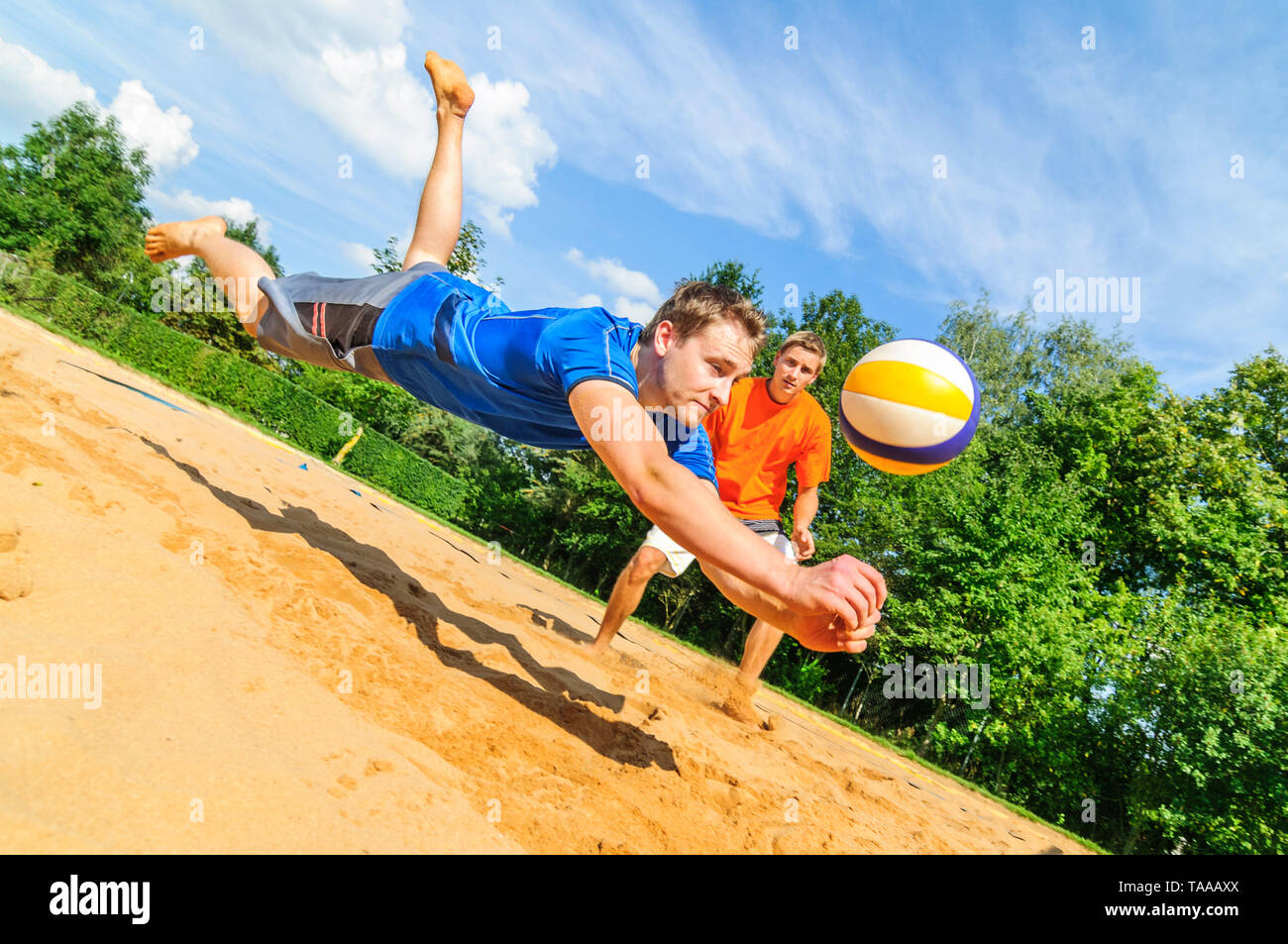 Gioco intensivo sul campo da pallavolo di spiaggia, lo spirito di lotta per salvare la sfera Foto Stock