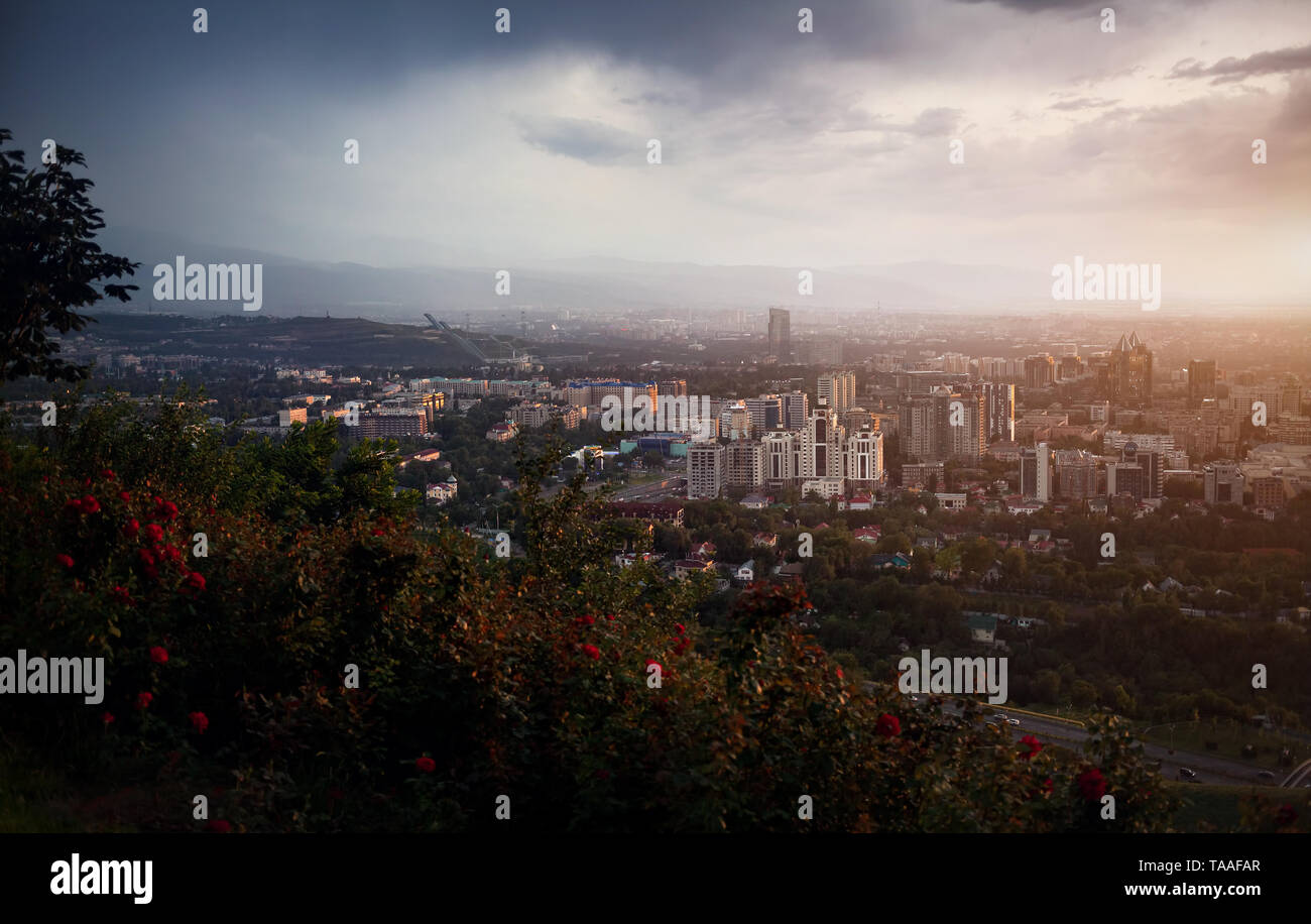 Almaty city view da Kok-tobe Mountain al drammatico tramonto tempestoso sullo sfondo del cielo Foto Stock