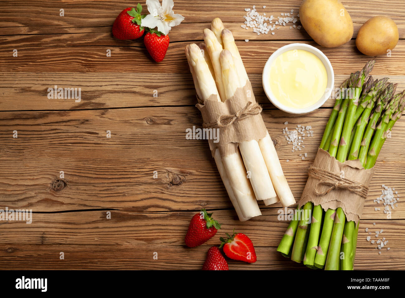 Fresco verde e asparagi bianchi con le fragole su tavola in legno rustico sfondo Foto Stock