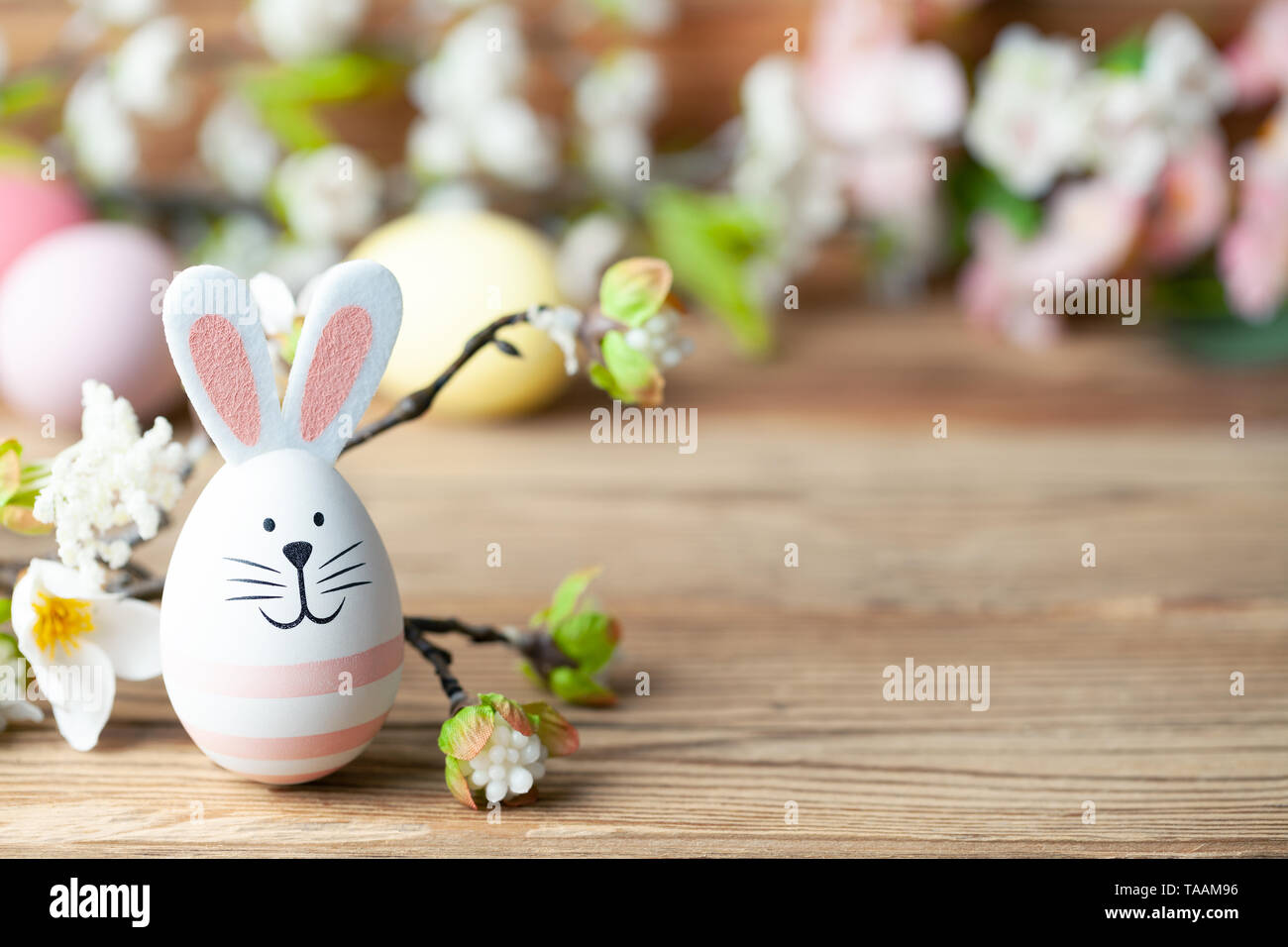 Felice Pasqua lo sfondo con il coniglietto di pasqua, uova di pasqua e fiori Foto Stock