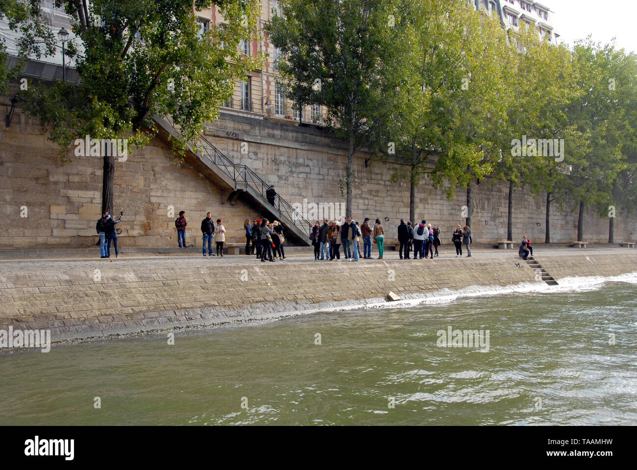 Un gruppo di persone in piedi sulla riva del fiume Senna, Parigi, Francia Foto Stock