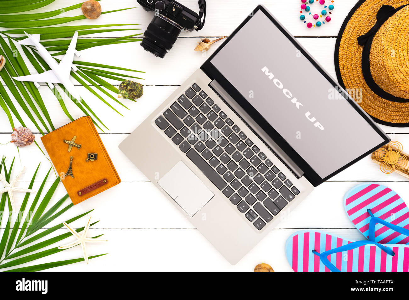 Mock up display del computer portatile su bianco tavolo in legno per Vacanze Estate vacanza il concetto di sfondo. Appartamento laici vista superiore del Notebook portatile, fotocamera accessor Foto Stock