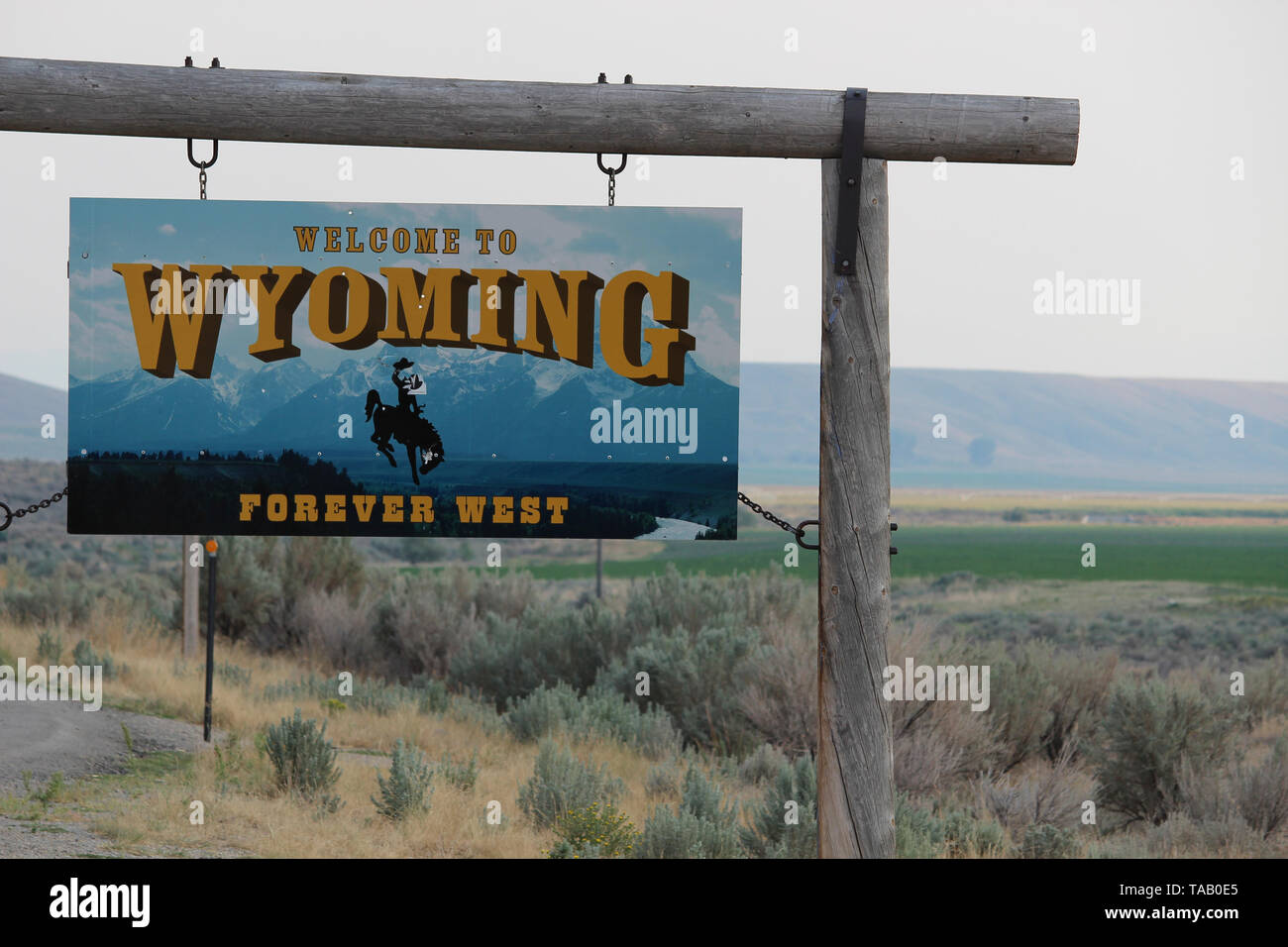 'Benvenuti al Wyoming' segno in linea di stato, rustico cartello in legno nel ranch di terra del paese. Foto Stock