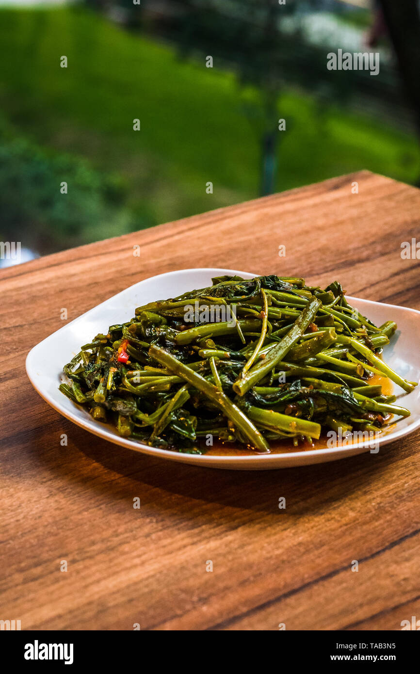 Stir fry sambal chili kang kong servita vegetale in un colore bianco porcellana piatto Foto Stock