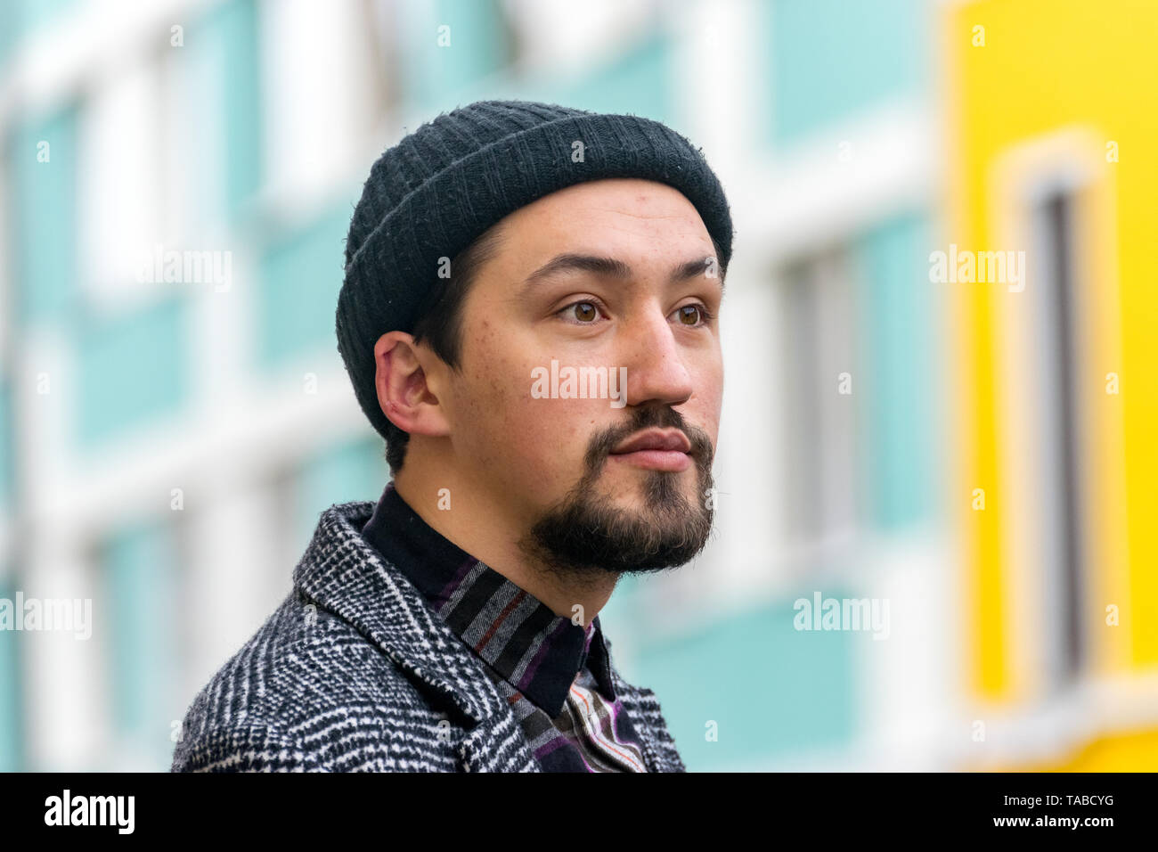 Ritratto di un elegante bel giovane con un rivestimento esterno. Un uomo che indossa un cappotto e una camicia che guarda lontano e pensando a. Foto Stock