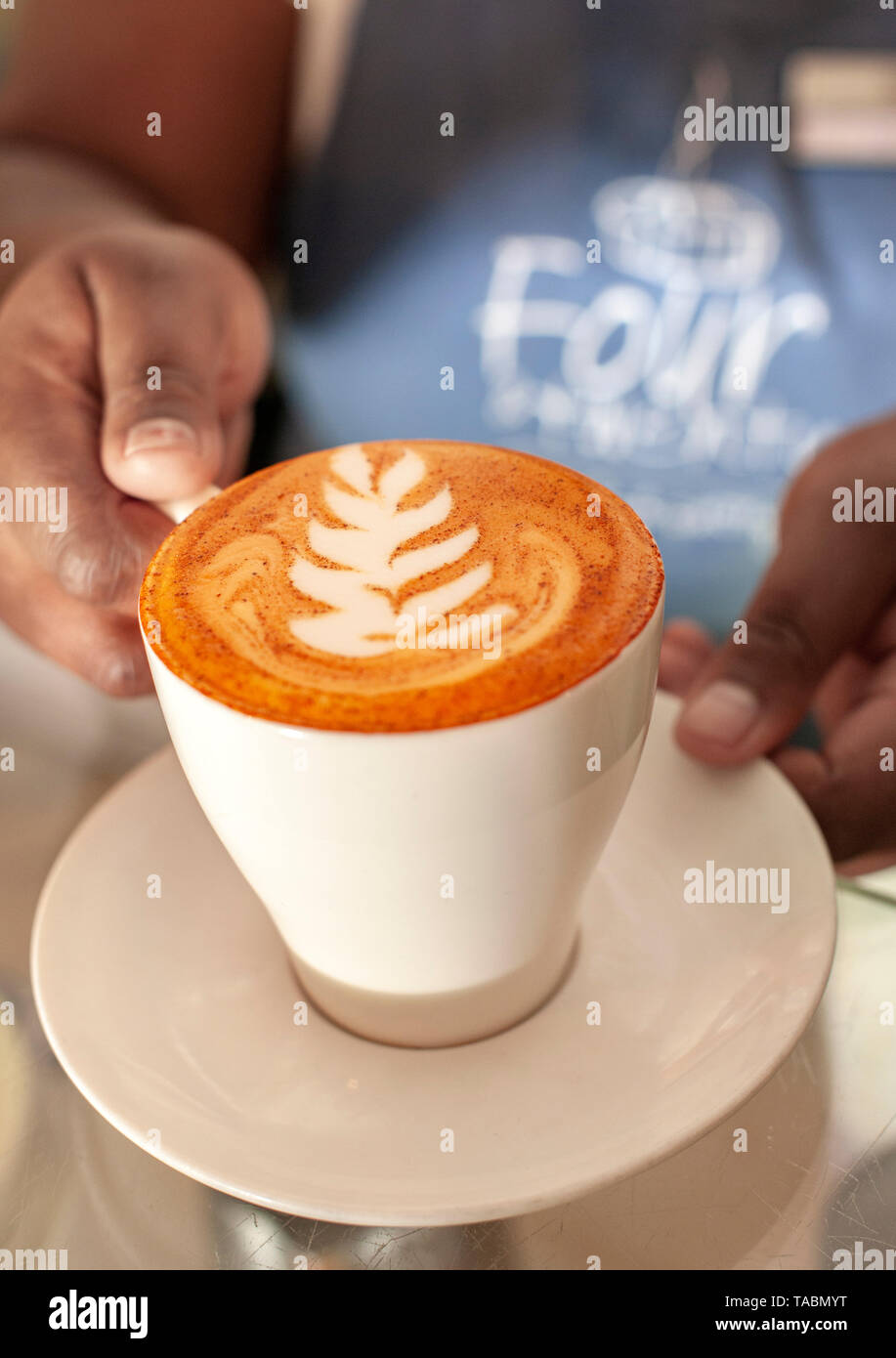 Tazza di cappuccino rosso (realizzata con rooibos tea) in quattro venti & Cafe a Cape Town. Il tè è distintivo di colore rosso è chiaramente visibile. Foto Stock