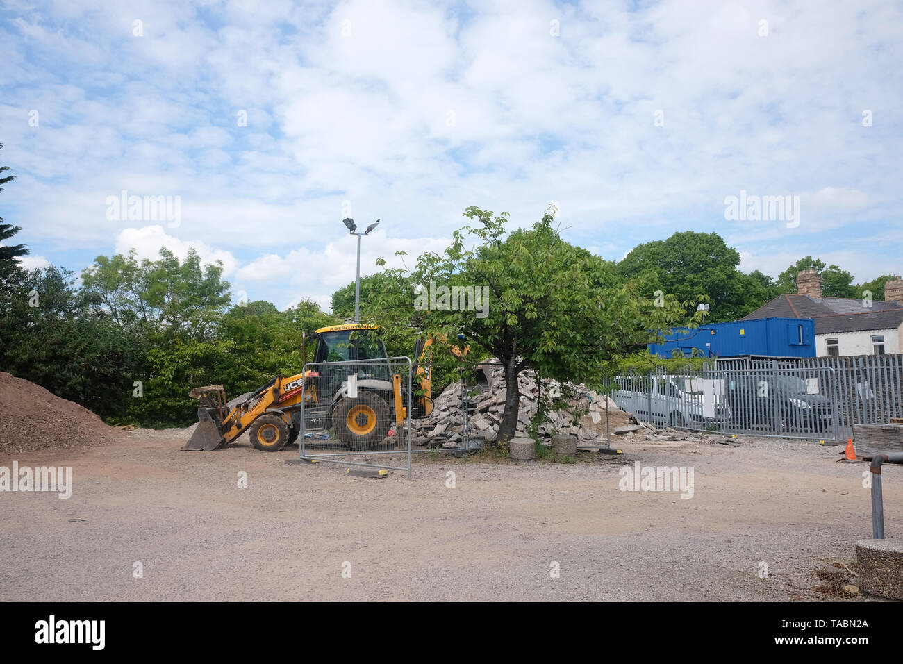Maggio 2019 - JCB back hoe escavatore in un cantiere dove la costruzione di pietra e di macerie vengono memorizzati Foto Stock