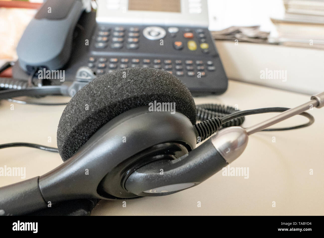 Cuffia con telefono in background in ufficio sulla scrivania Foto Stock