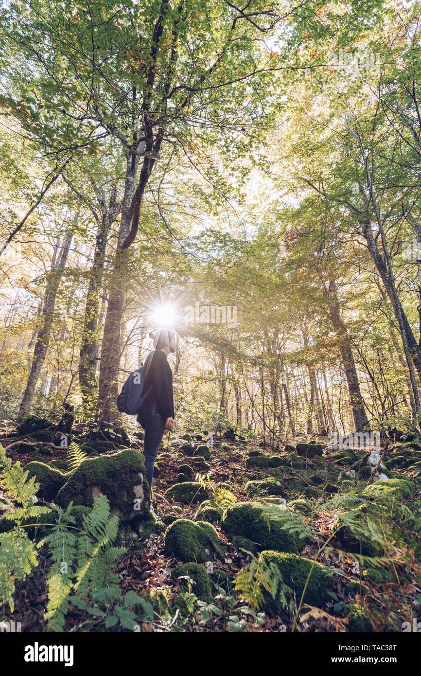 Spagna, Navarra, foresta di Irati, giovane donna in piedi nella lussureggiante foresta Foto Stock