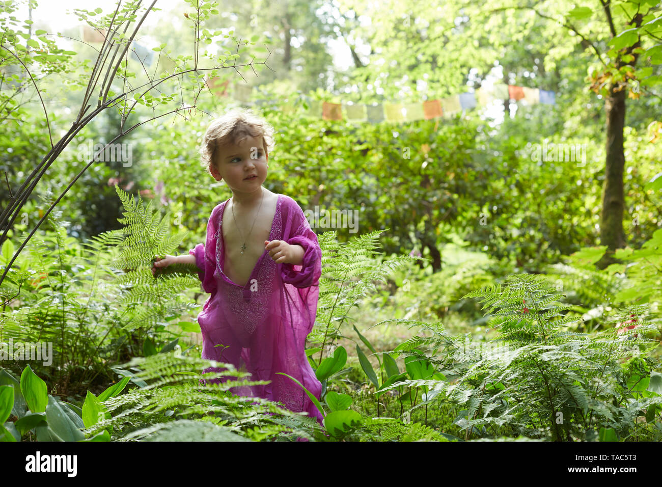 Bambina indossa tunica rosa in natura Foto Stock