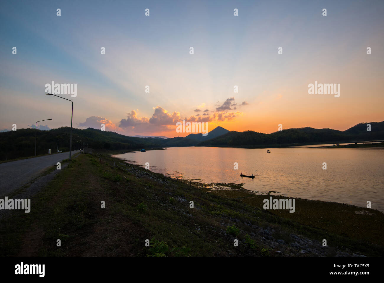 twilight sky river sunset blue and orange color landscape lake evening time clouds and silhouette mountains background Foto Stock