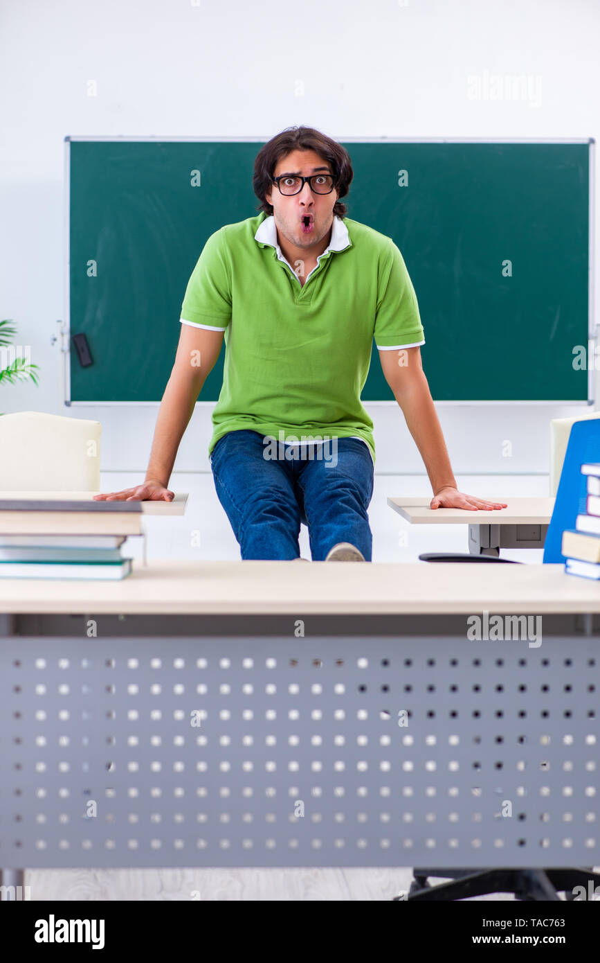 Giovane studente facendo esercizi fisici in aula Foto Stock