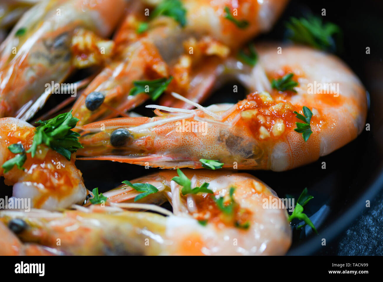 Piatto di frutti di mare con gamberi oceano cena gourmet di piatti di pesce cucinato con salsa di erbe e spezie sul pan background / Close up crostacei di gamberi cotti Foto Stock