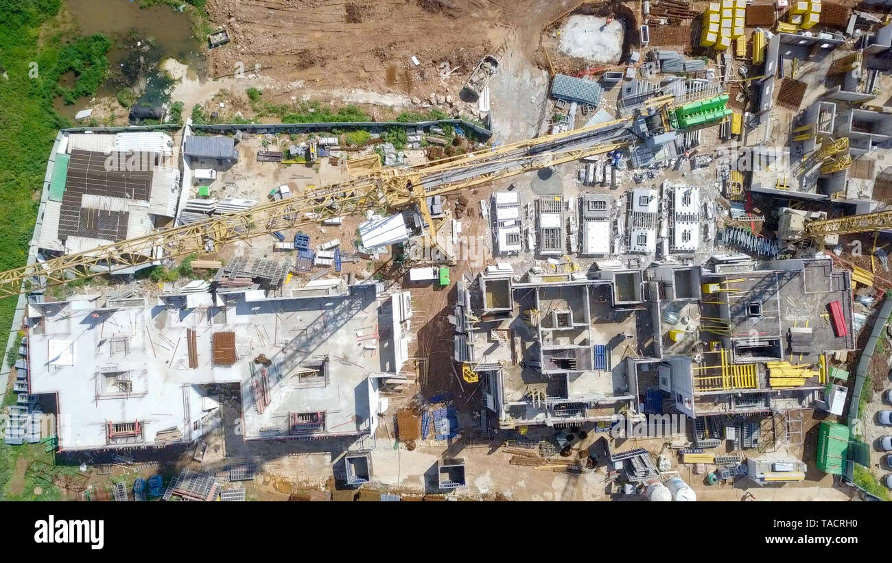 Sito in costruzione - immagine aerea di una grande zona residenziale composto durante le prime fasi di costruzione, con gru e verde ambiente circostante. Foto Stock
