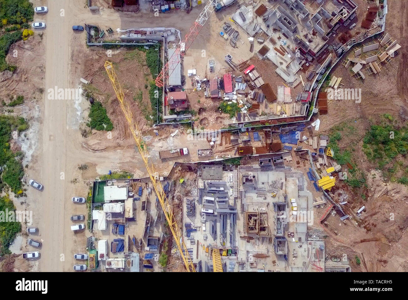 Sito in costruzione - immagine aerea di una grande zona residenziale composto durante le prime fasi di costruzione, con gru e verde ambiente circostante. Foto Stock