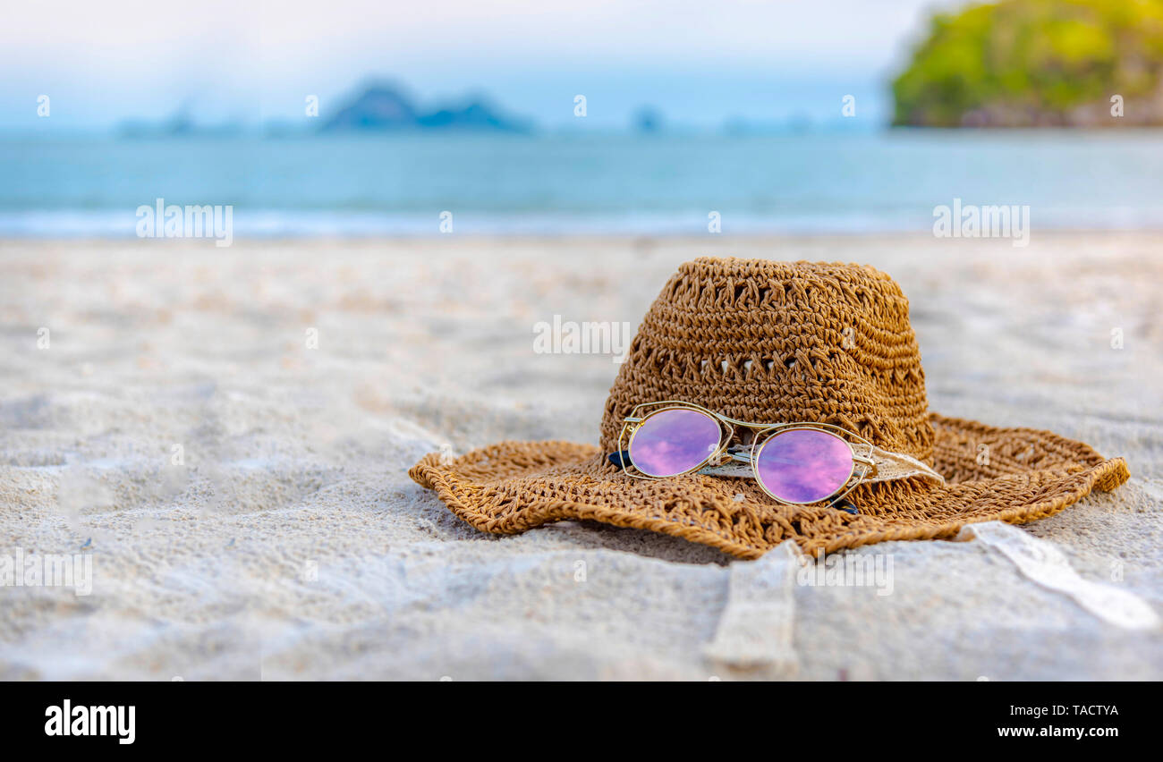 Cappelli e occhiali sono situati sulla spiaggia e mare blu, durante la  giornata di relax o lunghe vacanze Foto stock - Alamy