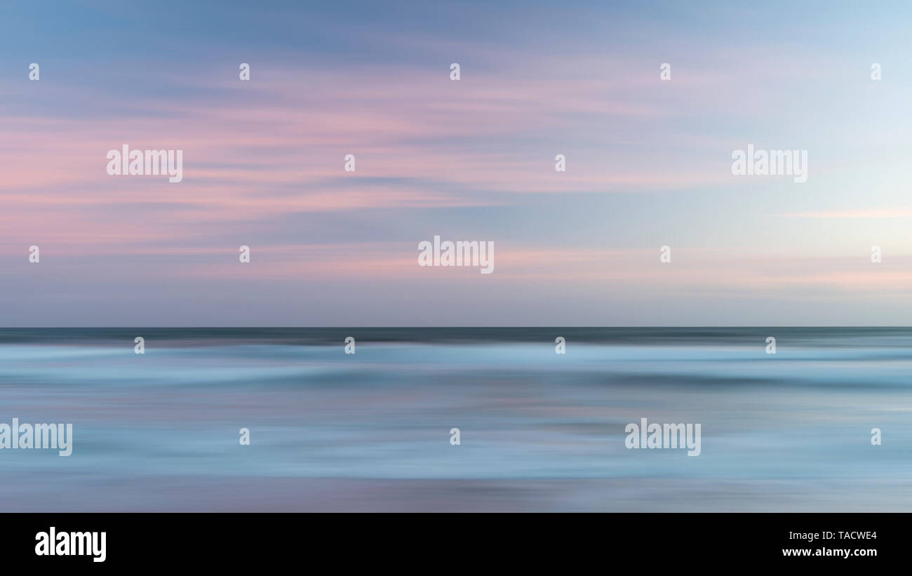 Bellissimo paesaggio colorato immagine di onde sfocata al tramonto nel Devon Enlgand Foto Stock