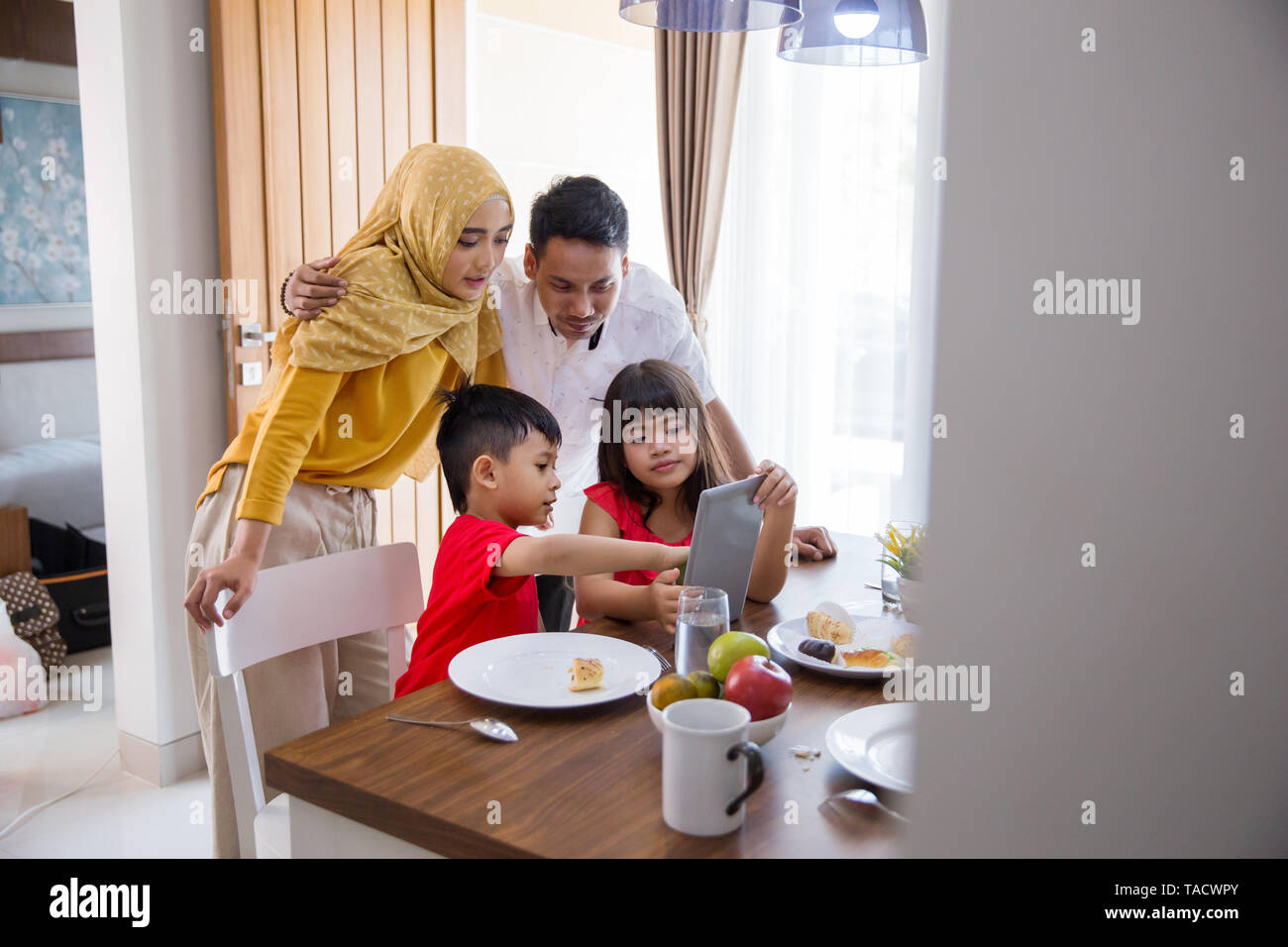 La famiglia tramite tablet pc a casa Foto Stock