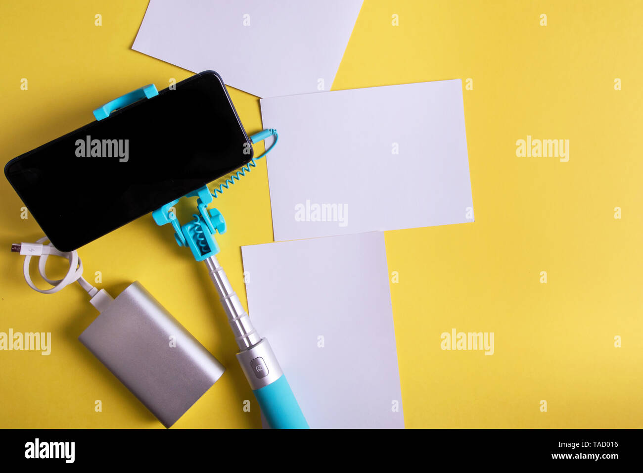 Piatto monopiede laici con uno smartphone e foto su uno sfondo giallo. Estate concetto di viaggio. Foto Stock