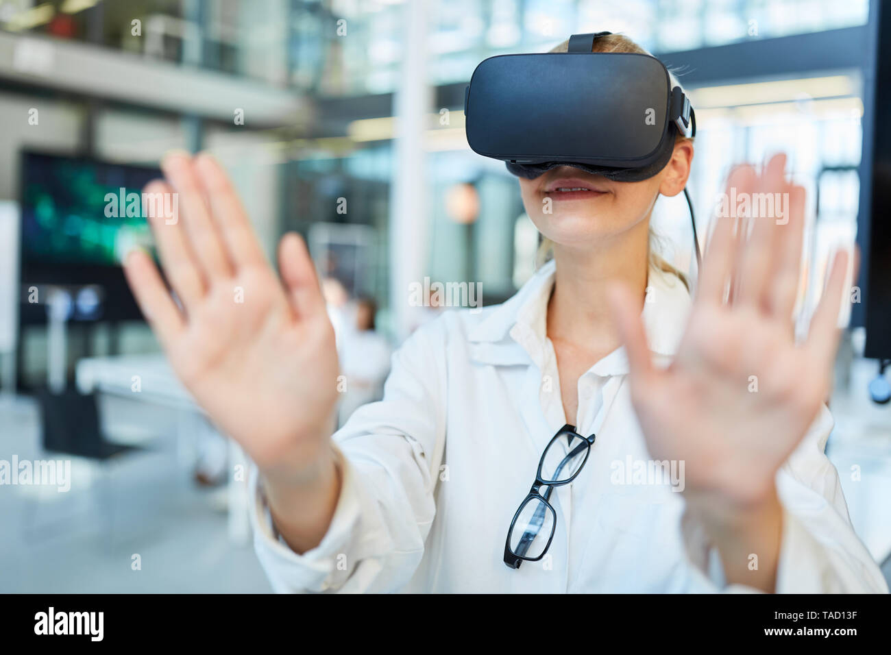 Medico donna apprende la medicina in simulazione con una realtà virtuale bicchieri Foto Stock