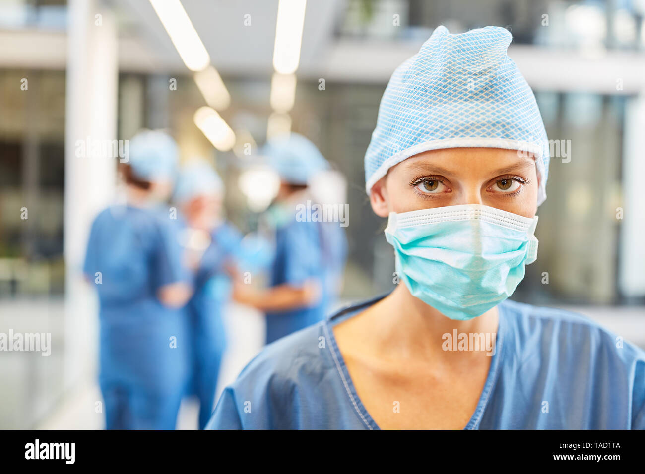 Giovane donna come un chirurgo o anestesista in blu abbigliamento chirurgico di fronte alla sala di emergenza Foto Stock