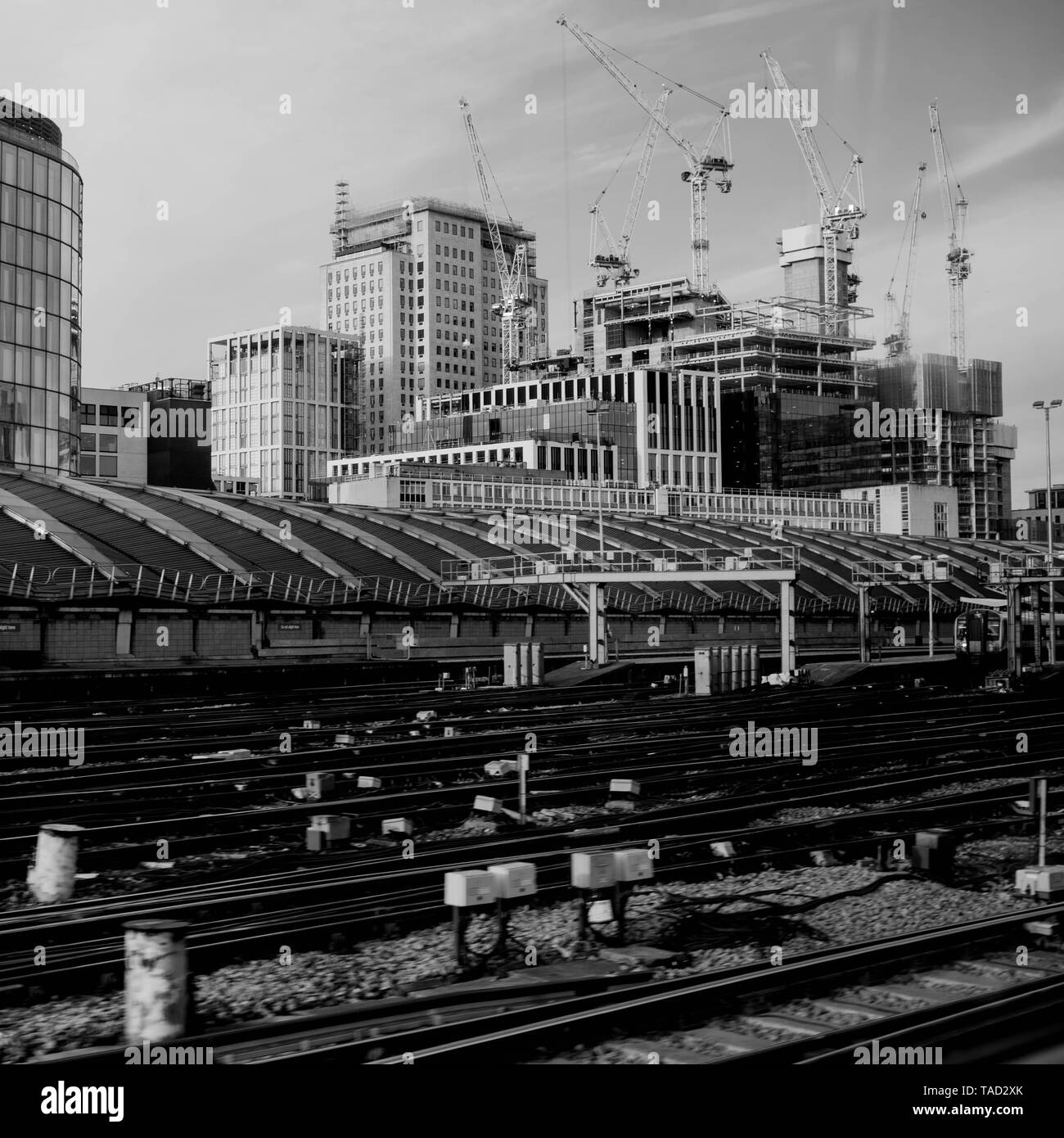 I binari ferroviari lasciando la stazione di Waterloo a Londra senza treni o persone con gru a torre e lavori di costruzione in background Foto Stock