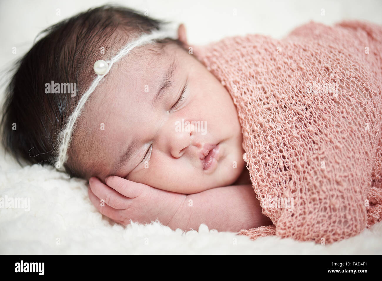 Dormire in wrap neonato ragazza close-up verticale Foto Stock