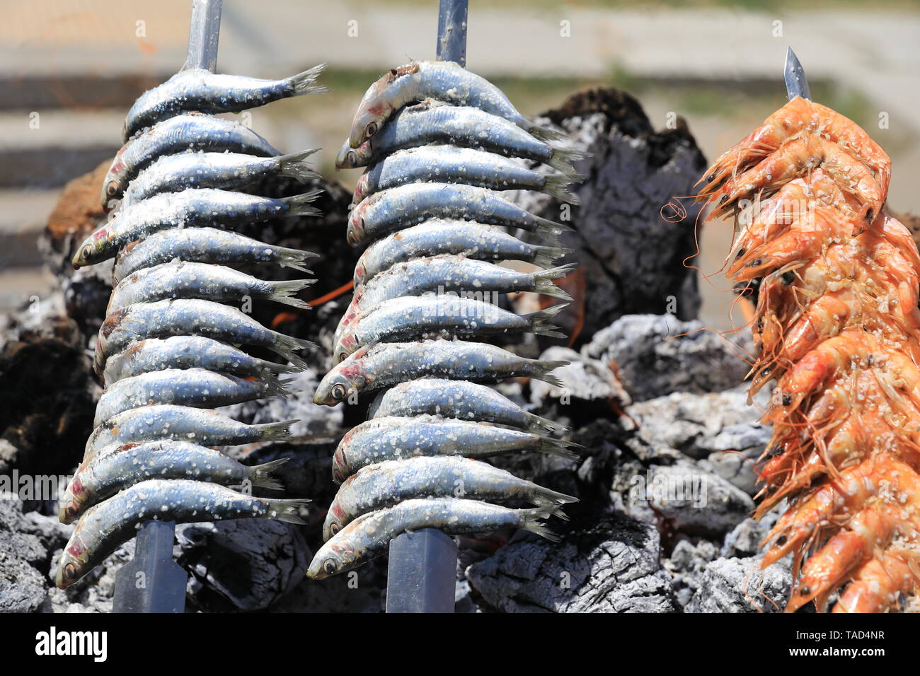 Le sardine fresche alla griglia essendo sulla spiaggia Malagueta, nel centro di Malaga sulla Costa del Sol in Spagna, Europa Foto Stock