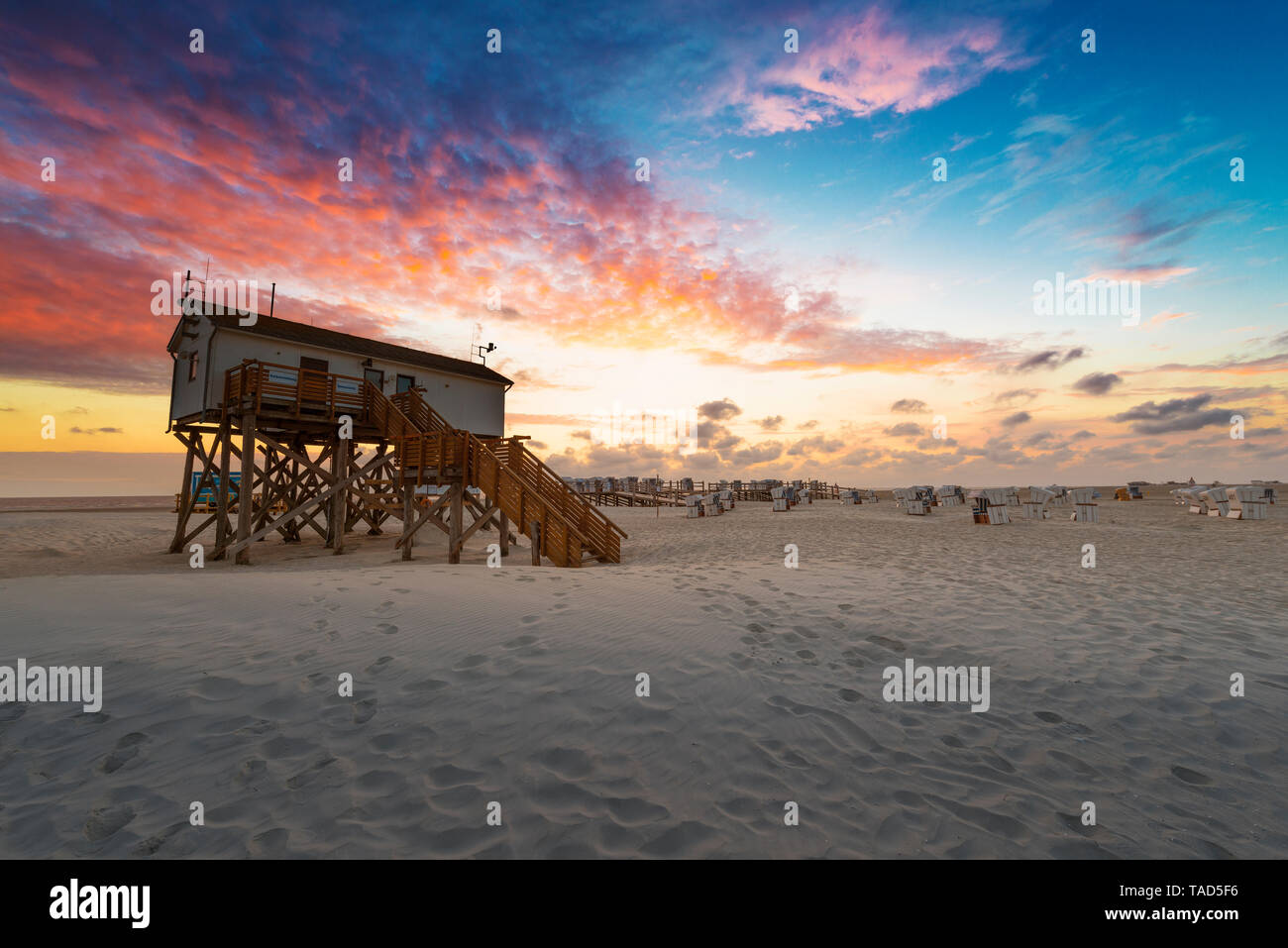 Germania, Sankt Peter Ording, stazioni palafitticole sulla spiaggia di tramonto Foto Stock