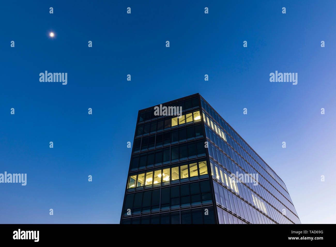 Germania, Stoccarda, finestre illuminate a ufficio moderno edificio a ora di blu Foto Stock