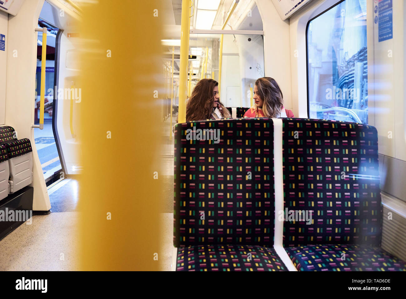 UK, Londra, due donne che parlano in treno sotterraneo Foto Stock