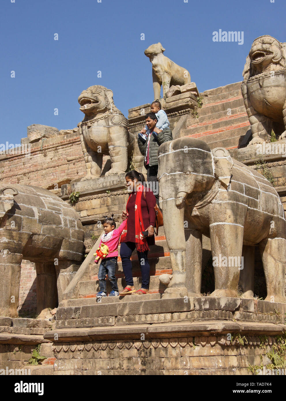 Pietra scolpita custode degli animali passi di fianco di rovinato Silu Mahadev Temple, Durbar Square, Bhaktapur, Valle di Kathmandu, Nepal Foto Stock