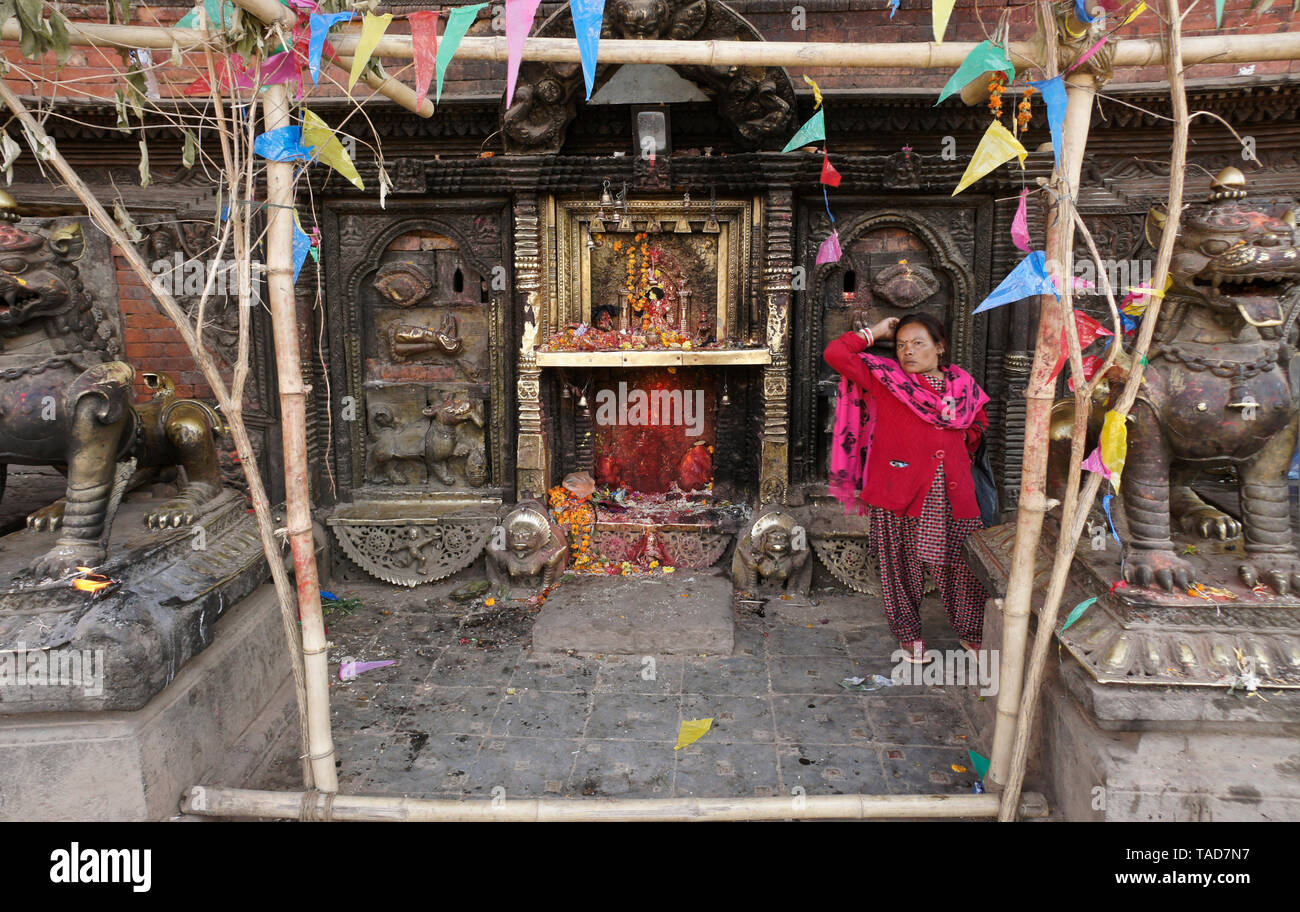 Donna adorando nel piccolo santuario indù a base di Bhairabnath Mandir, Taumadhi Tol, Bhakatapur, Valle di Kathmandu, Nepal Foto Stock