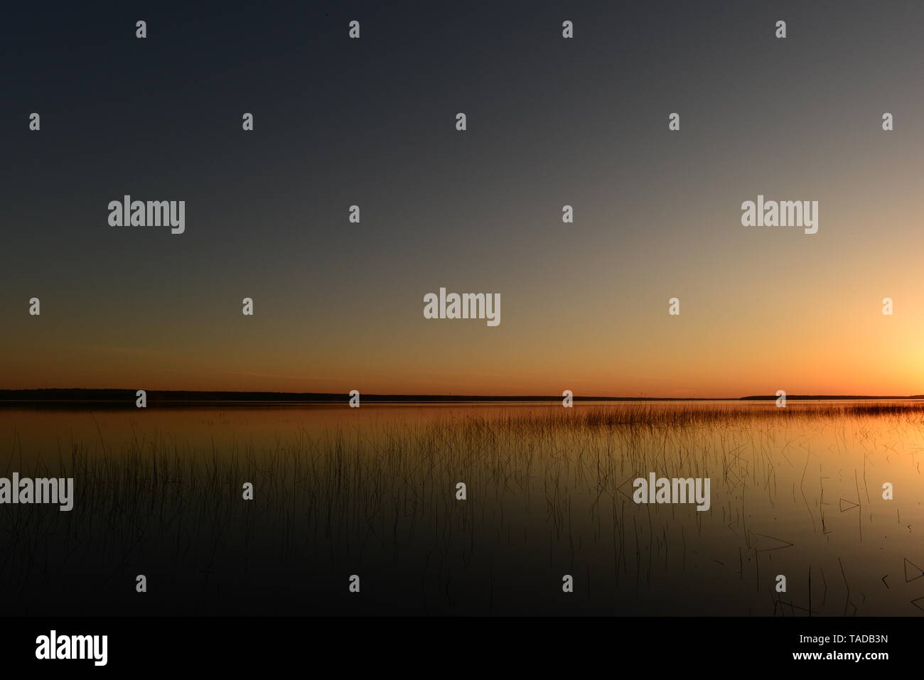 Molla blu limpido cielo sopra il lago in luminosi colori del tramonto di luce e ombre Foto Stock